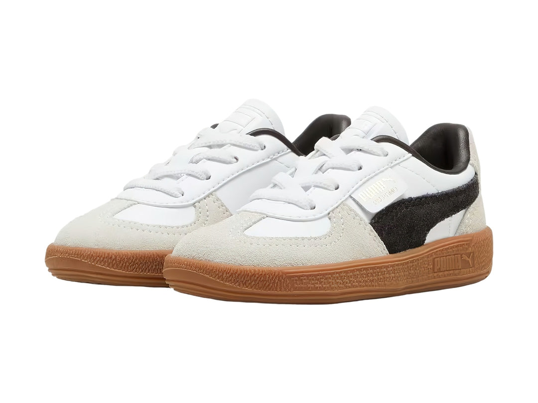 Tenis PUMA Palermo para bebé en color blanco con detalles en gris y negro y suela de goma café.