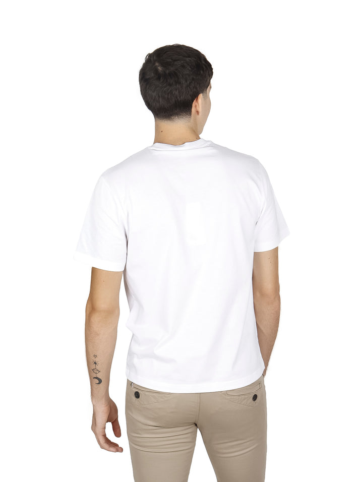 Hombre vistiendo una camiseta blanca de manga corta con cuello redondo de la marca Lacoste.
