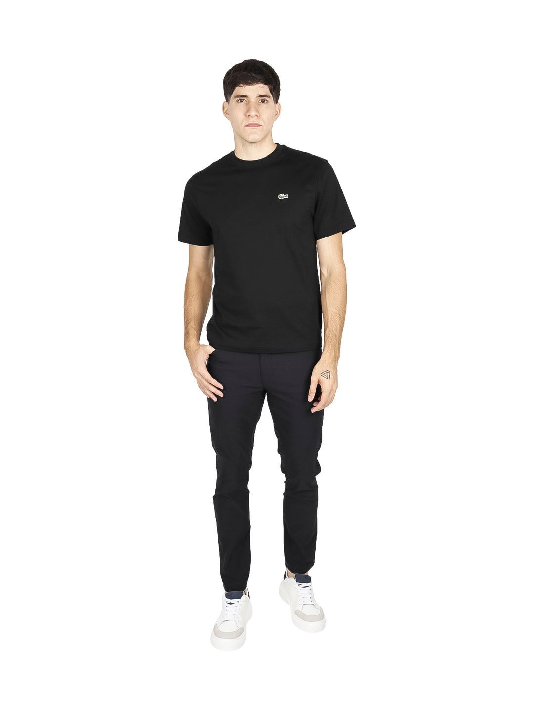 Hombre vistiendo una camiseta de manga corta color negro de la marca Lacoste.