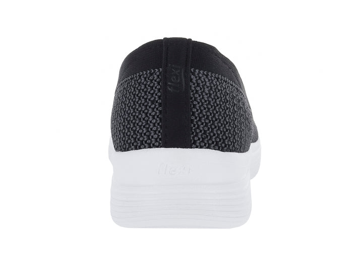 Zapato plano Flexi estilo slip-on en color negro con suela blanca gruesa.