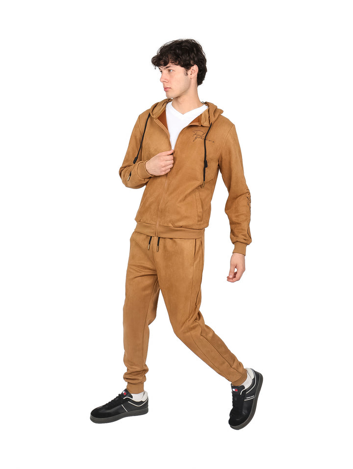 Hombre vistiendo un conjunto deportivo color café compuesto por sudadera con capucha y pantalón.