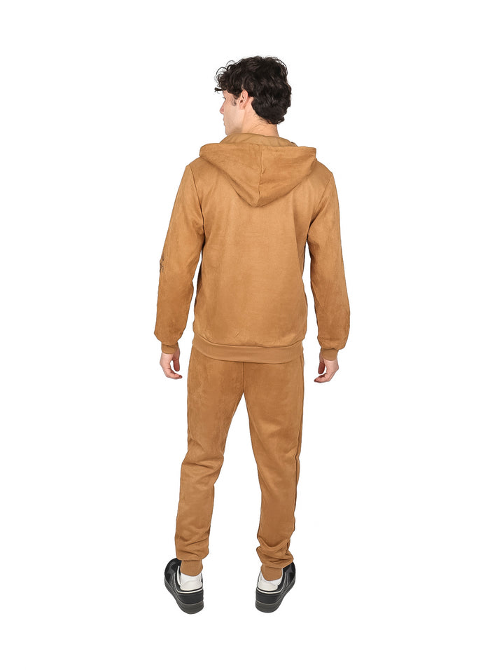 Hombre vistiendo un conjunto deportivo color café compuesto por sudadera con capucha y pantalón.