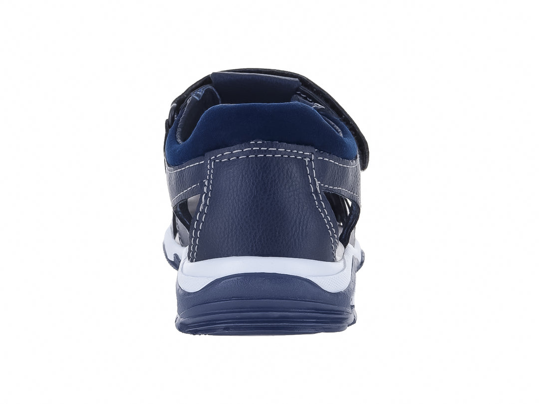Sandalia cerrada para niño en color azul marino con suela blanca y ajuste de velcro.