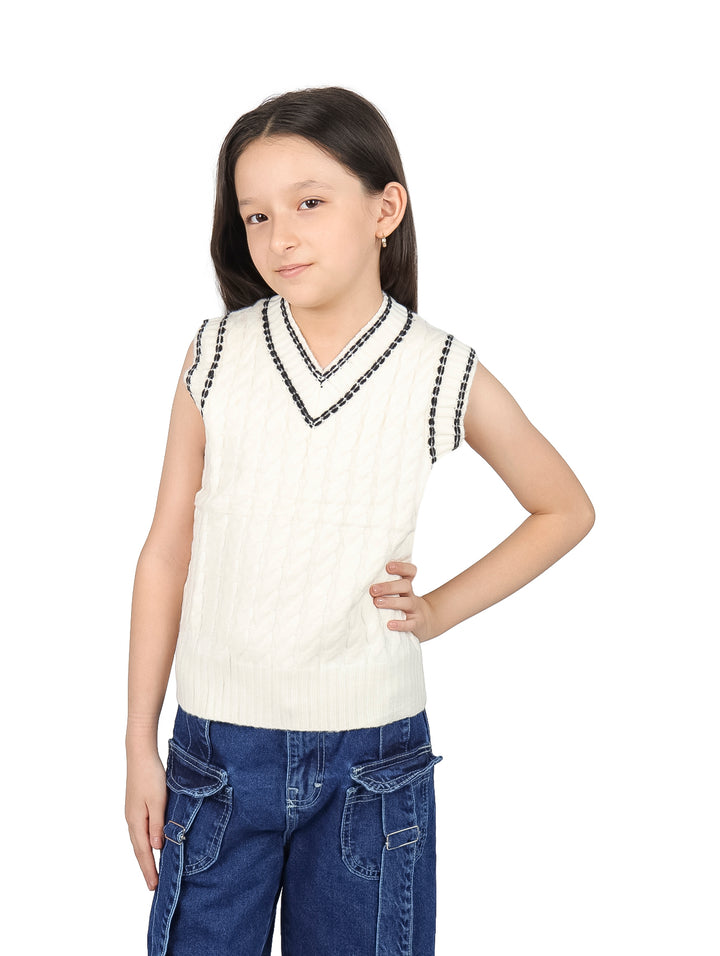 Niña vistiendo un chaleco de punto color ivory con cuello en V y detalles en negro.
