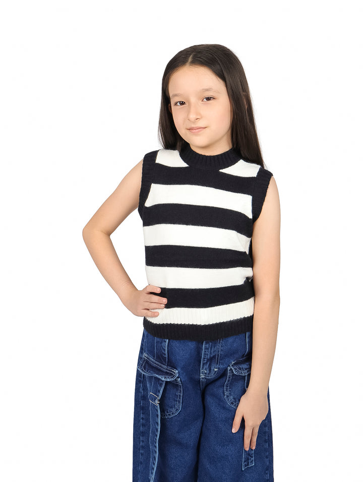 Niña vistiendo un chaleco de rayas horizontales negras y blancas y pantalones de mezclilla azules.