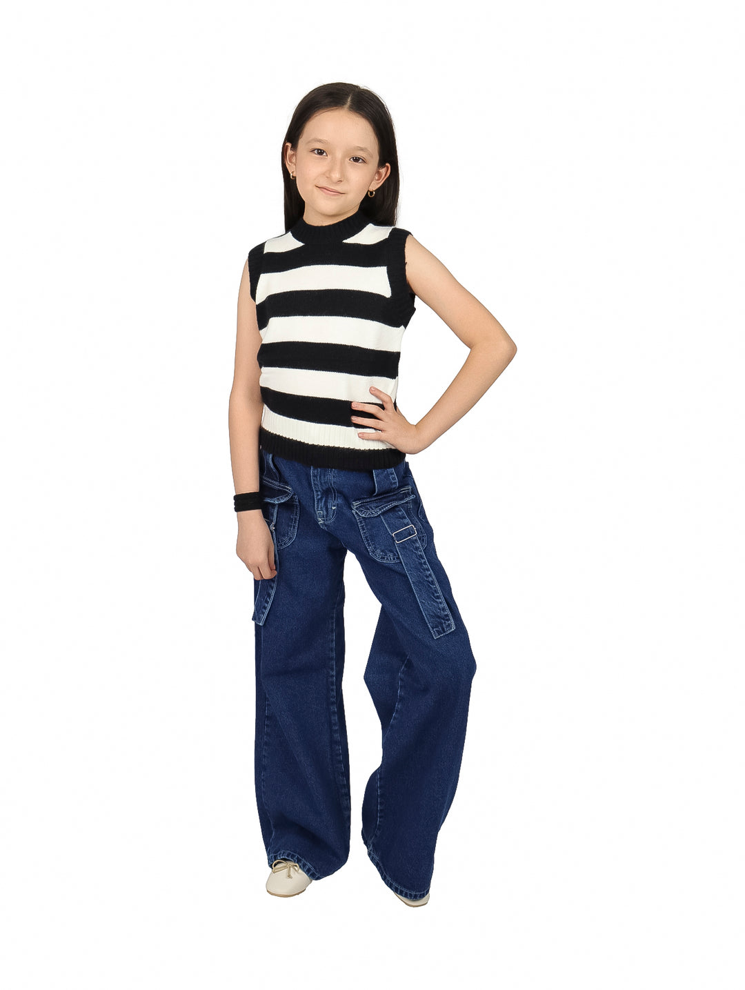 Niña vistiendo un chaleco de rayas horizontales negras y blancas y pantalones de mezclilla azules.