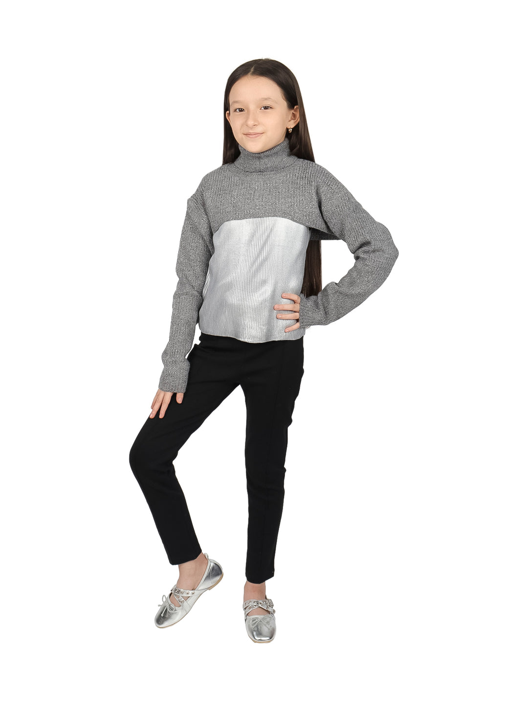 Niña vistiendo blusa de cuello alto en colores gris y plateado con pantalones negros.