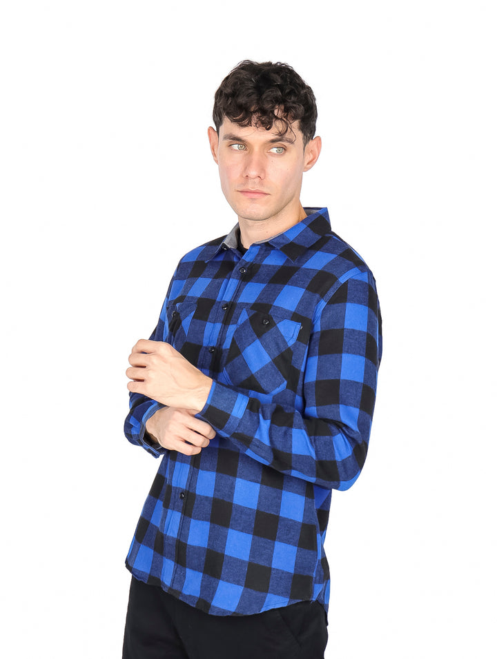 Hombre vistiendo camisa de franela a cuadros en colores azul y negro de manga larga.