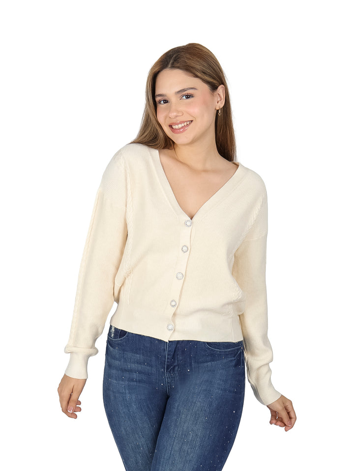 Mujer vistiendo un suéter beige de cuello en V con botones frontales.
