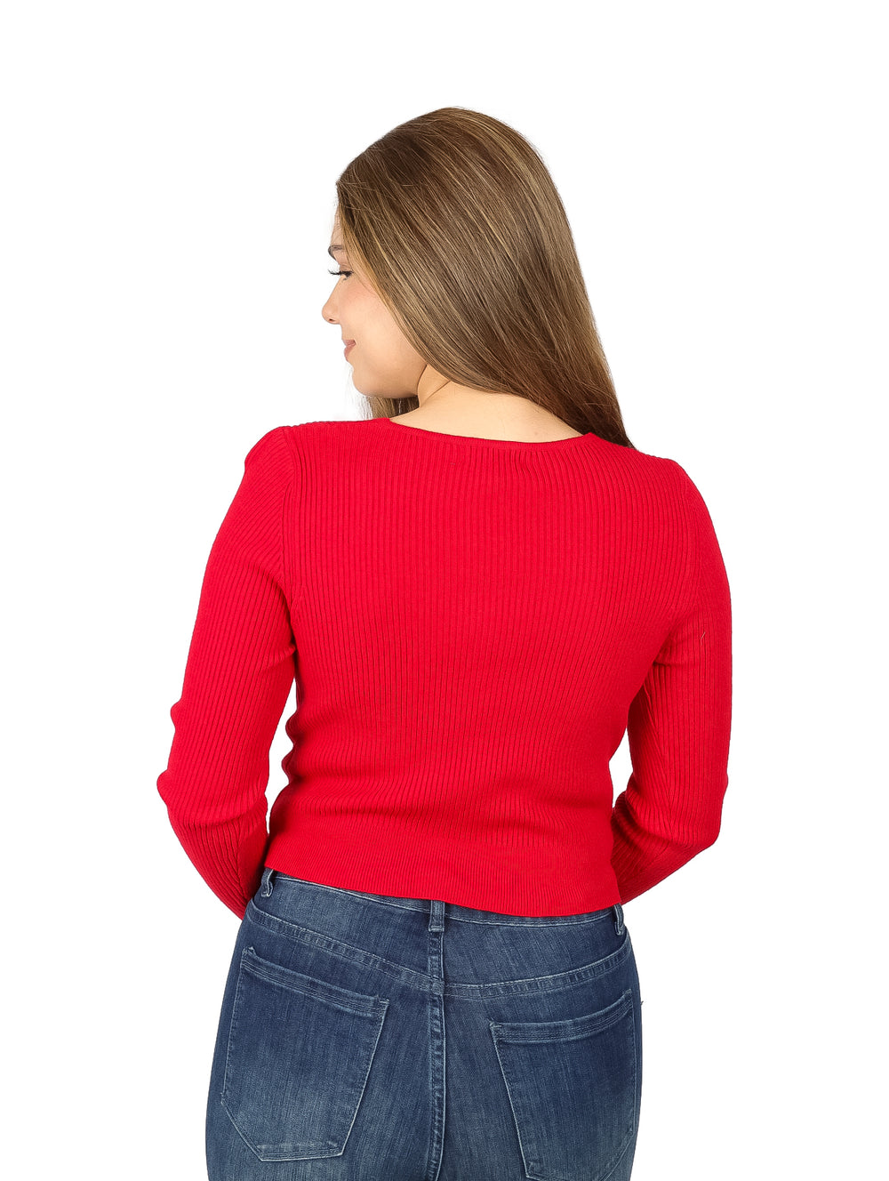 Mujer vistiendo suéter rojo de cuello en V con botones y pantalones vaqueros azules.
