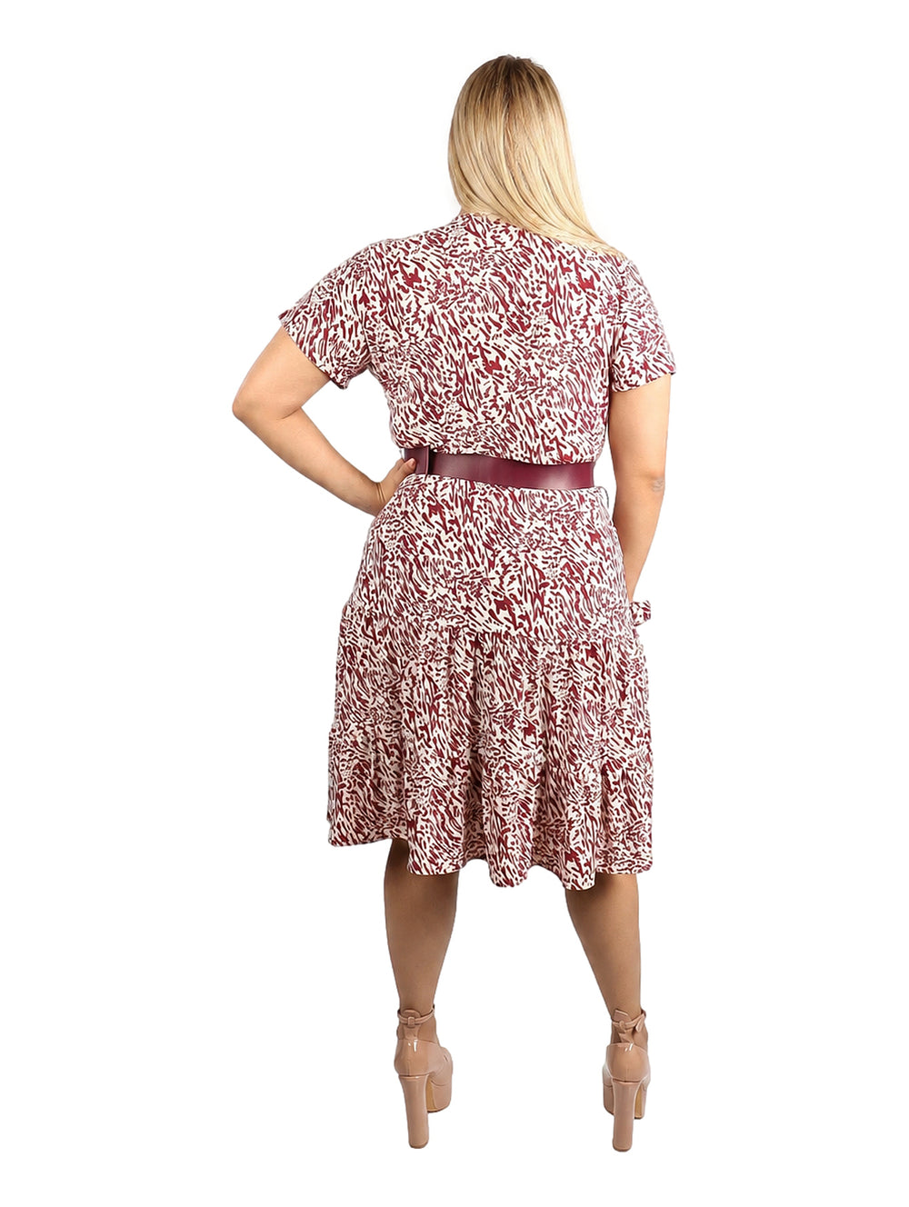 Mujer con vestido corto estampado en rojo y blanco con cinturón rojo.