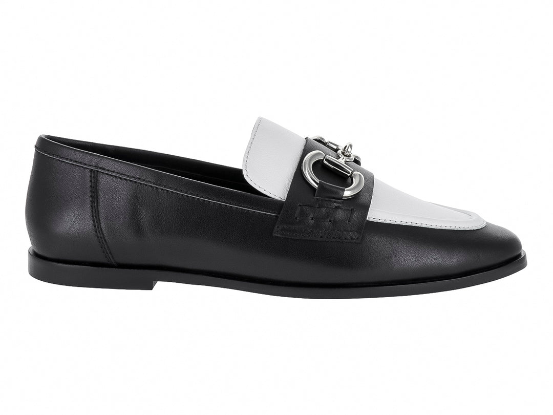 Zapato tipo mocasín Jeffrey Campbell en colores negro y blanco con hebilla plateada metálica.