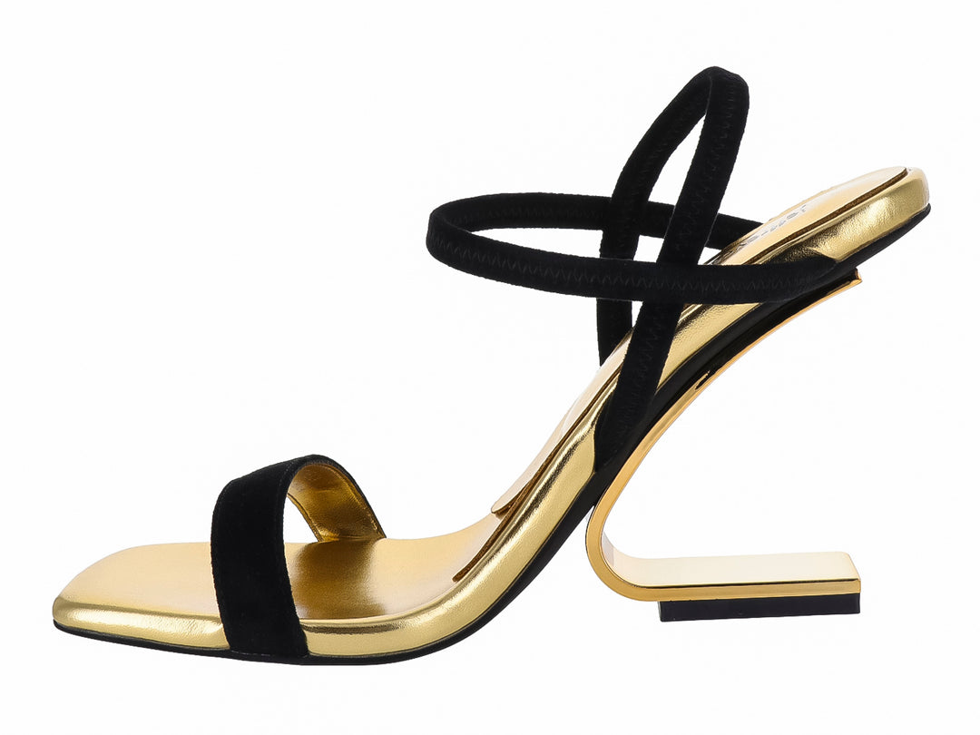 Sandalia Jeffrey Campbell negra con suela y tacón geométrico en color dorado brillante.