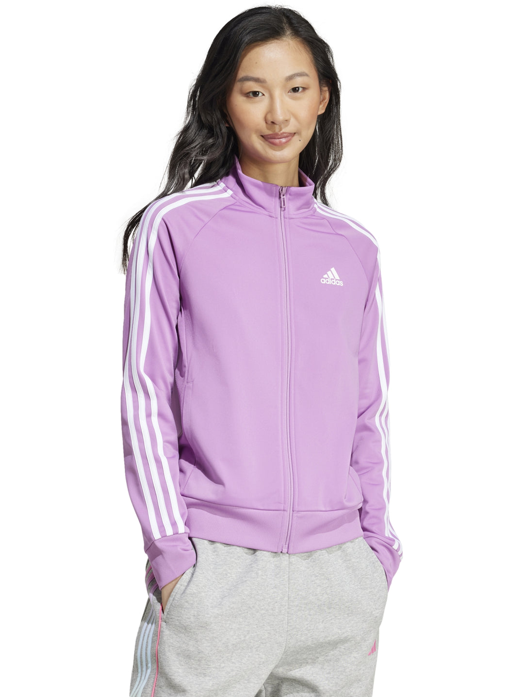 Chaqueta deportiva Adidas de color rosa con rayas blancas en las mangas y cierre frontal.