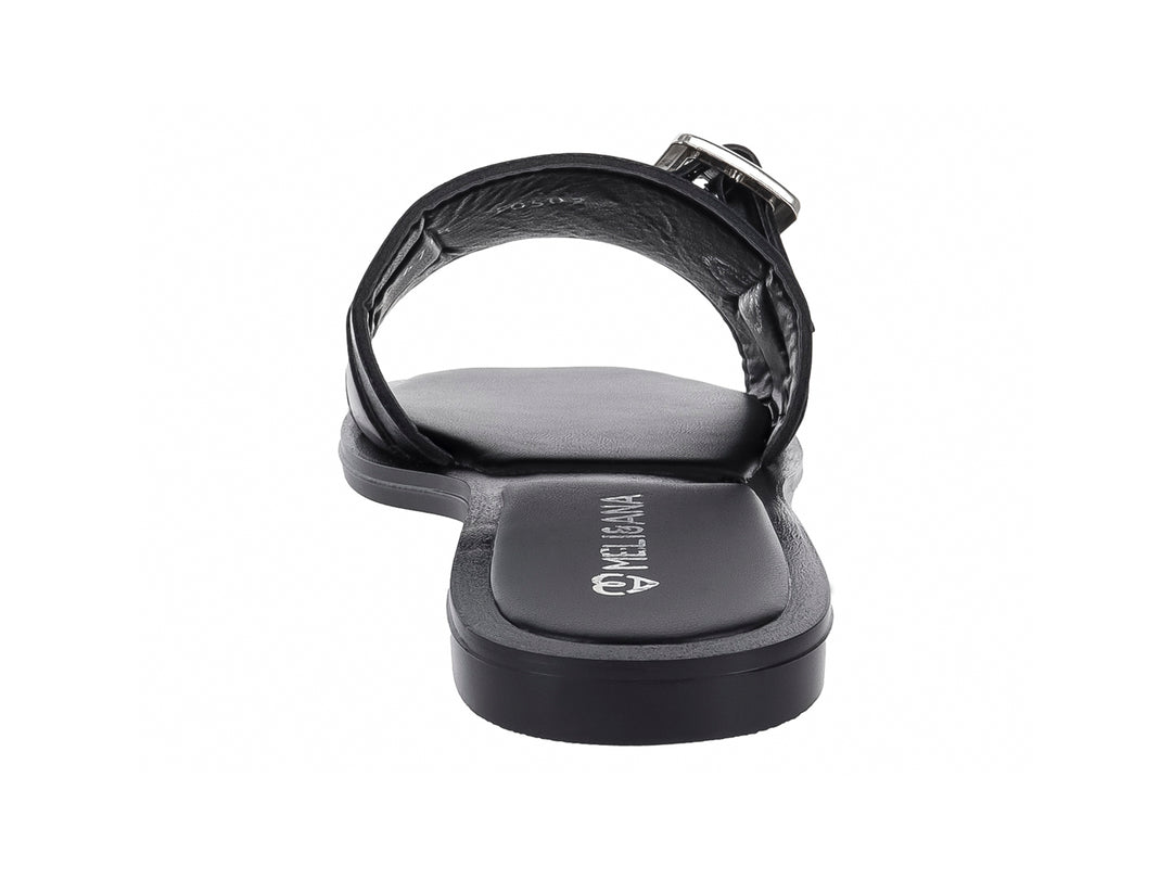 Sandalia plana color negro para mujer con una ancha banda frontal y hebilla metálica plateada.