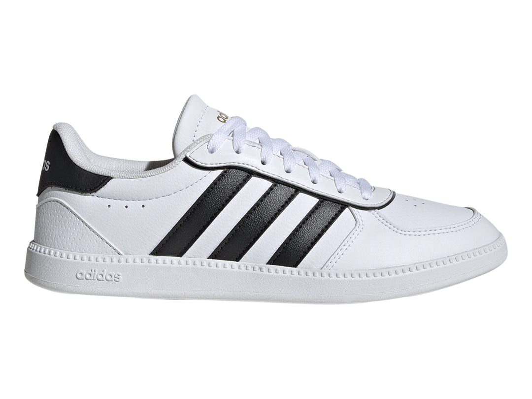 Tenis Adidas blancos con tres franjas negras laterales y suela blanca.