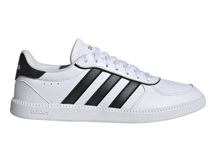 Tenis Adidas blancos con tres franjas negras laterales y suela blanca.