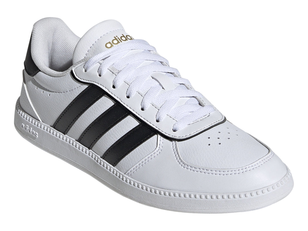 Tenis Adidas blancos con tres franjas negras laterales y suela blanca.