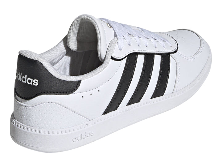 Tenis Adidas blancos con tres franjas negras laterales y suela blanca.