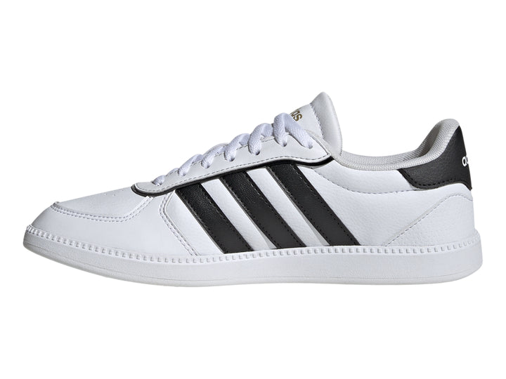Tenis Adidas blancos con tres franjas negras laterales y suela blanca.