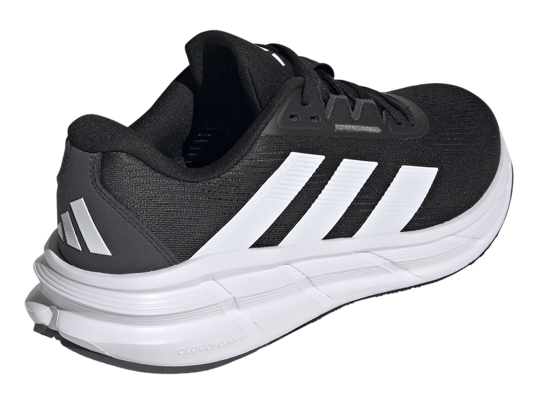 Tenis deportivos Adidas Questar 3 en color negro con suela blanca y tres franjas blancas laterales.