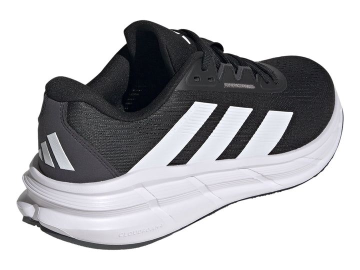 Tenis deportivos Adidas Questar 3 en color negro con suela blanca y tres franjas blancas laterales.