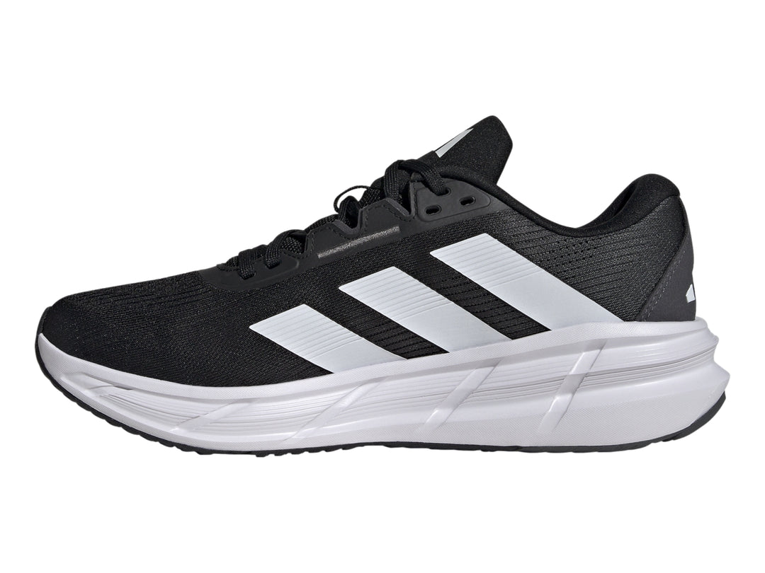 Tenis deportivos Adidas Questar 3 en color negro con suela blanca y tres franjas blancas laterales.