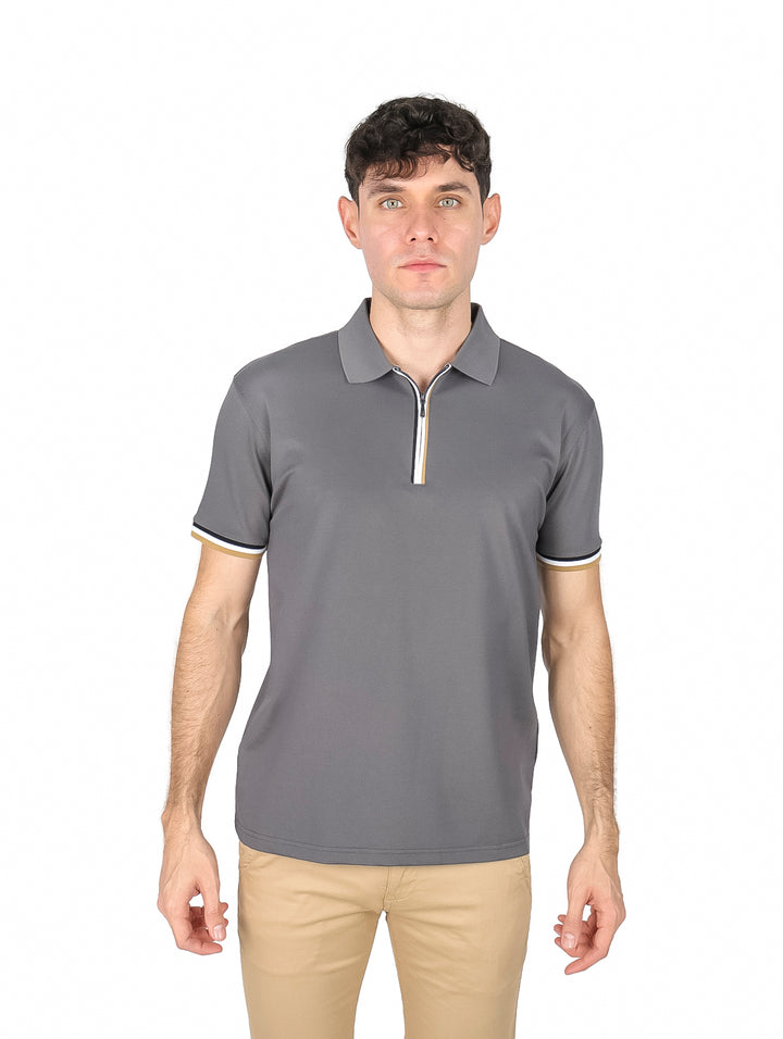 Hombre vistiendo playera polo color charcoal con detalles en blanco y dorado en el cuello y mangas.
