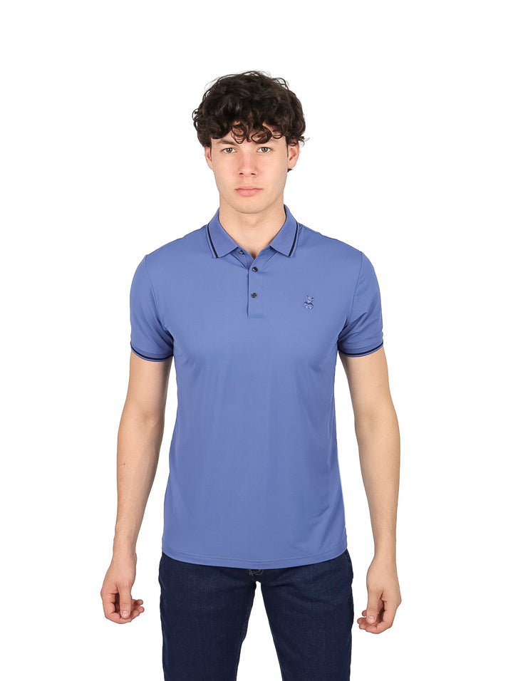 Hombre vistiendo playera tipo polo color azul con detalles oscuros en el cuello y los bordes de las mangas.