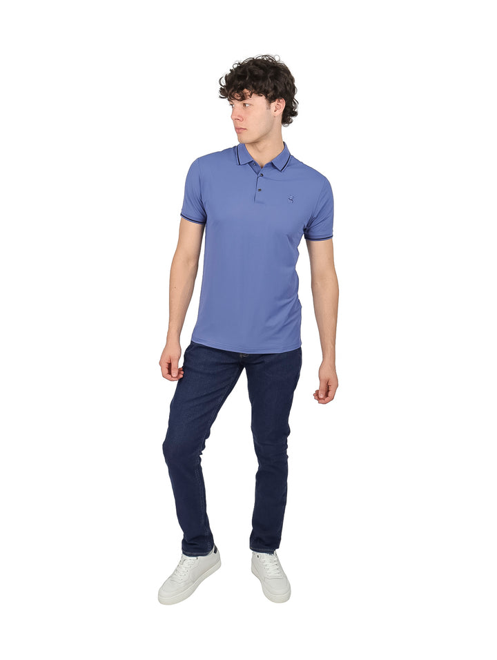Hombre vistiendo playera tipo polo color azul con detalles oscuros en el cuello y los bordes de las mangas.