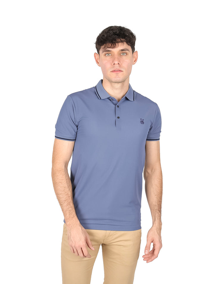 Hombre vistiendo playera tipo polo color azul gris con detalles oscuros en cuello y mangas.