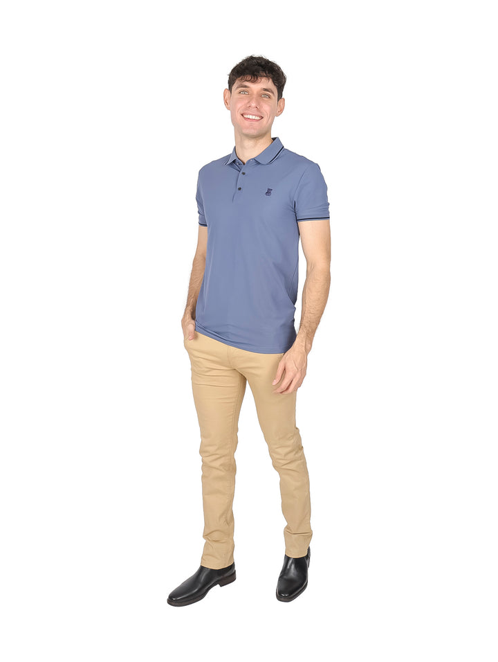 Hombre vistiendo playera tipo polo color azul gris con detalles oscuros en cuello y mangas.