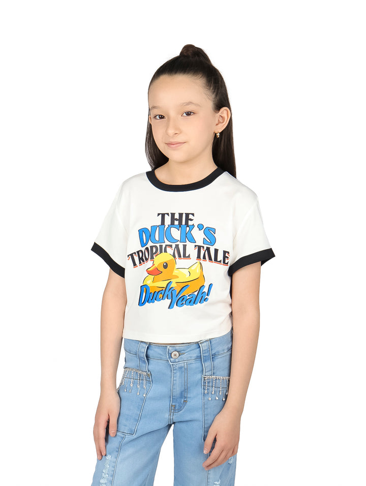 Niña vistiendo camiseta corta blanca con estampado de pato y ribete negro en las mangas.