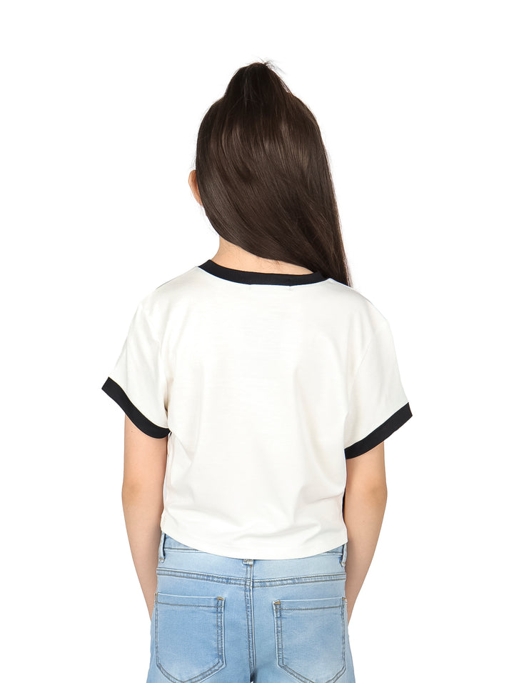 Niña vistiendo camiseta corta blanca con estampado de pato y ribete negro en las mangas.