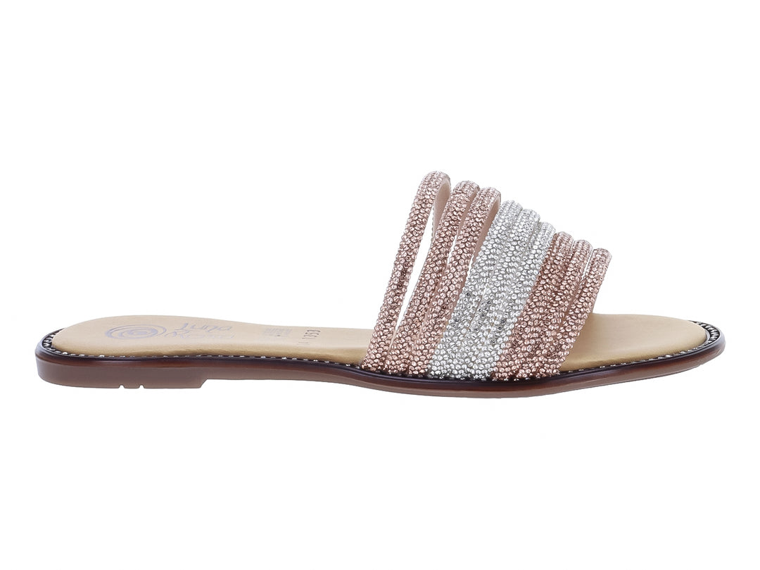 Sandalia plana con tiras de pedrería en tonos plata y rosa maquillaje sobre suela beige.