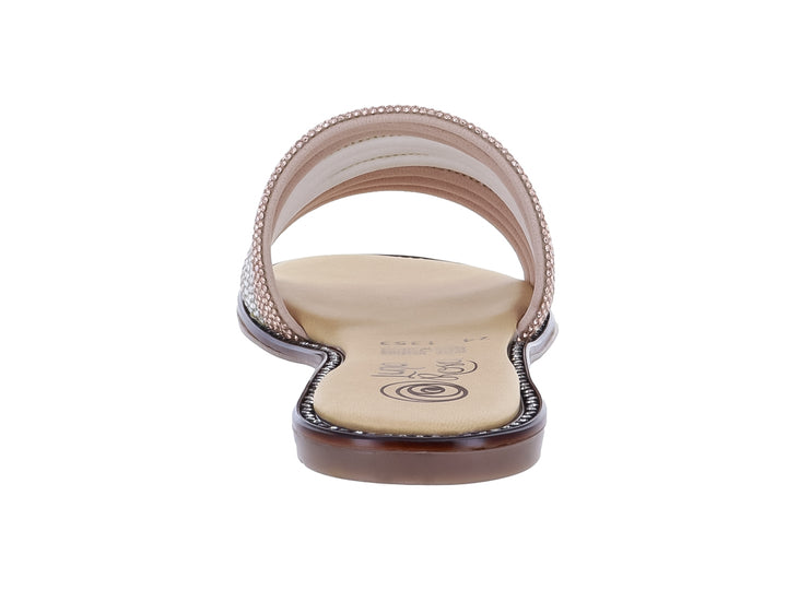 Sandalia plana con tiras de pedrería en tonos plata y rosa maquillaje sobre suela beige.