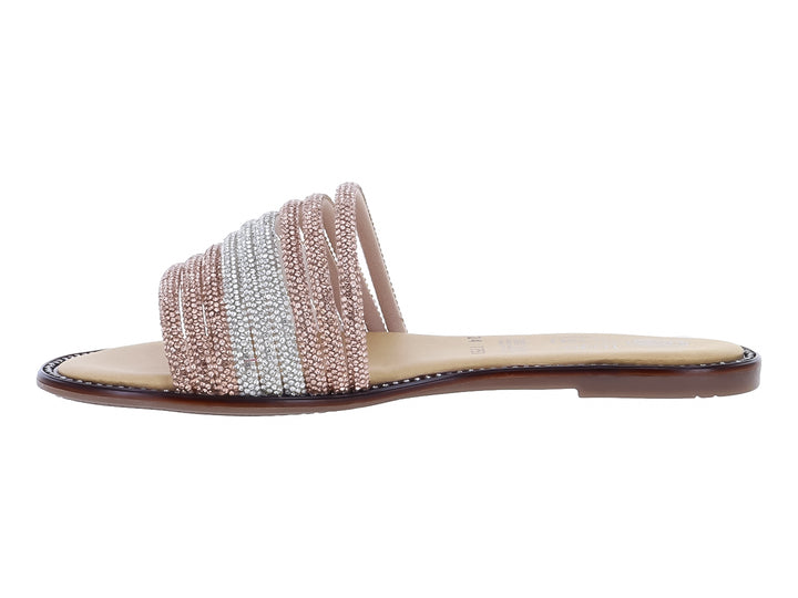 Sandalia plana con tiras de pedrería en tonos plata y rosa maquillaje sobre suela beige.
