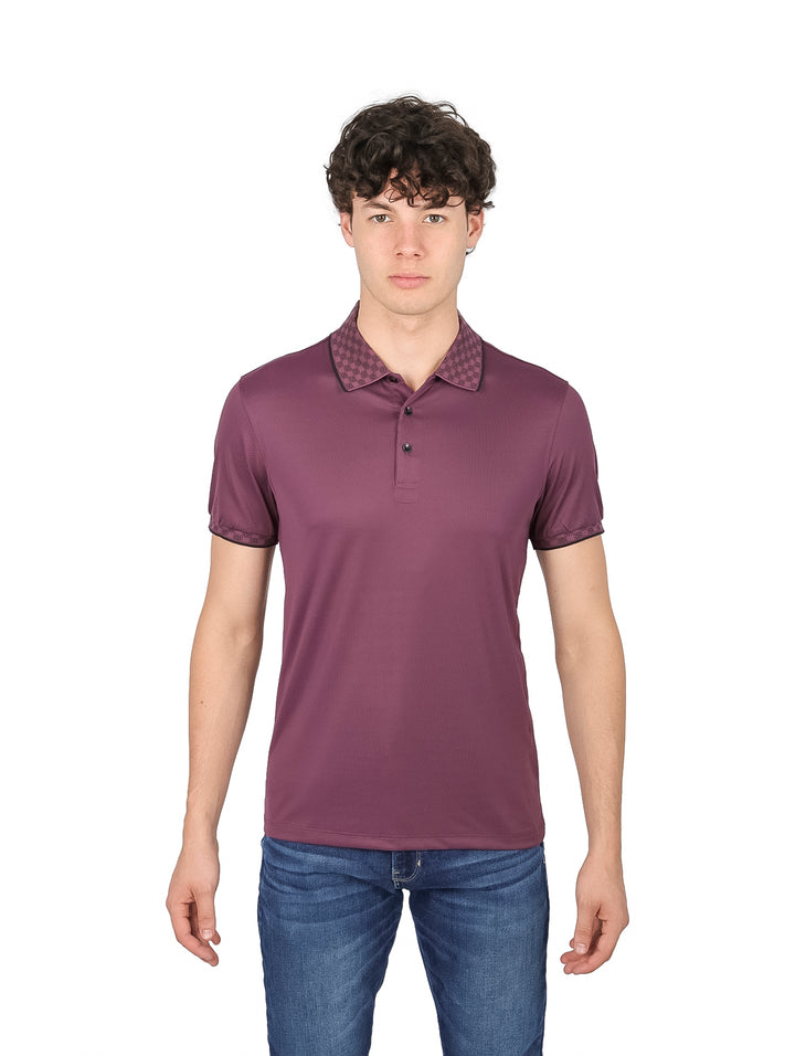 Hombre vistiendo una playera tipo polo color morado con detalles en el cuello y mangas.