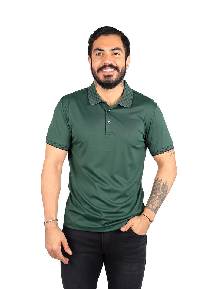 Hombre vistiendo playera tipo polo color verde oscuro con detalles decorativos en el cuello y mangas.