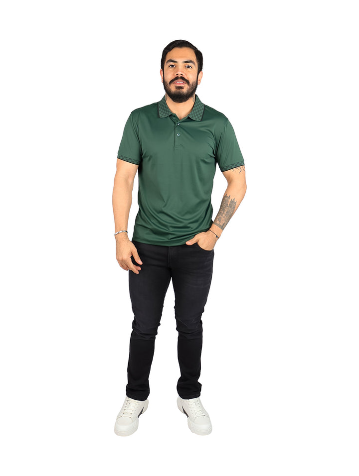 Hombre vistiendo playera tipo polo color verde oscuro con detalles decorativos en el cuello y mangas.
