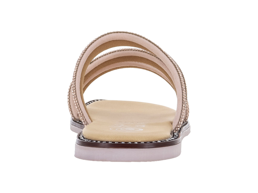 Sandalia plana color maquillaje con tiras brillantes decoradas y suela blanca.
