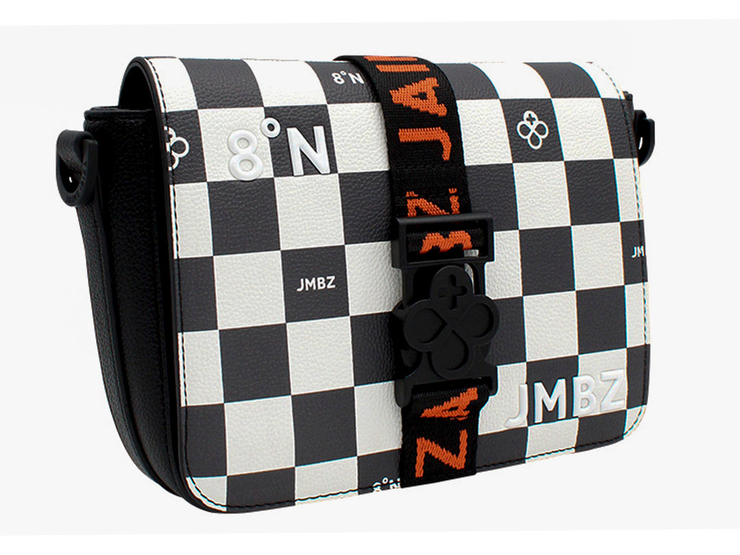 Bolso bandolera Jaime Ibiza con estampado de cuadros blancos y negros, detalles en naranja y correa ajustable.