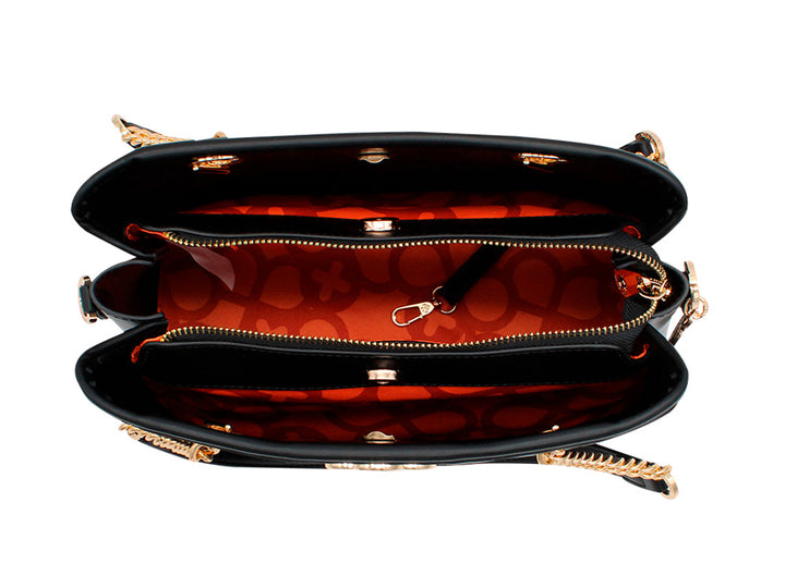 Bolso negro con textura grabada y detalles de cadena dorada en las asas.