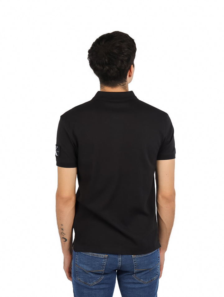 Hombre vistiendo una camiseta polo negra de manga corta Calvin Klein.