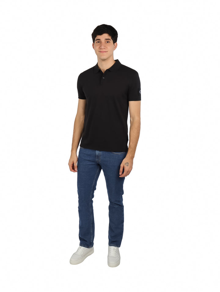 Hombre vistiendo una camiseta polo negra de manga corta Calvin Klein.