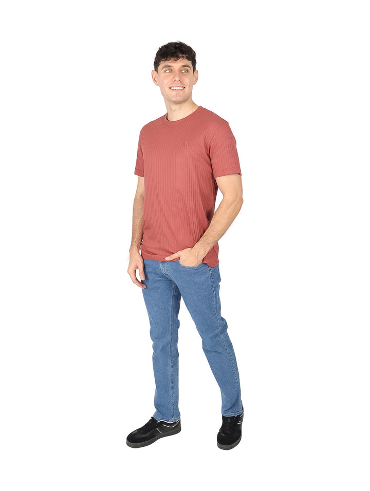Hombre usando camiseta de manga corta color terracota con textura de líneas verticales.