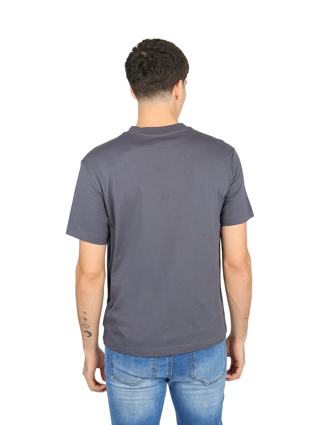 Hombre vistiendo una camiseta de manga corta color gris oscuro con estampado de texto blanco en el pecho.