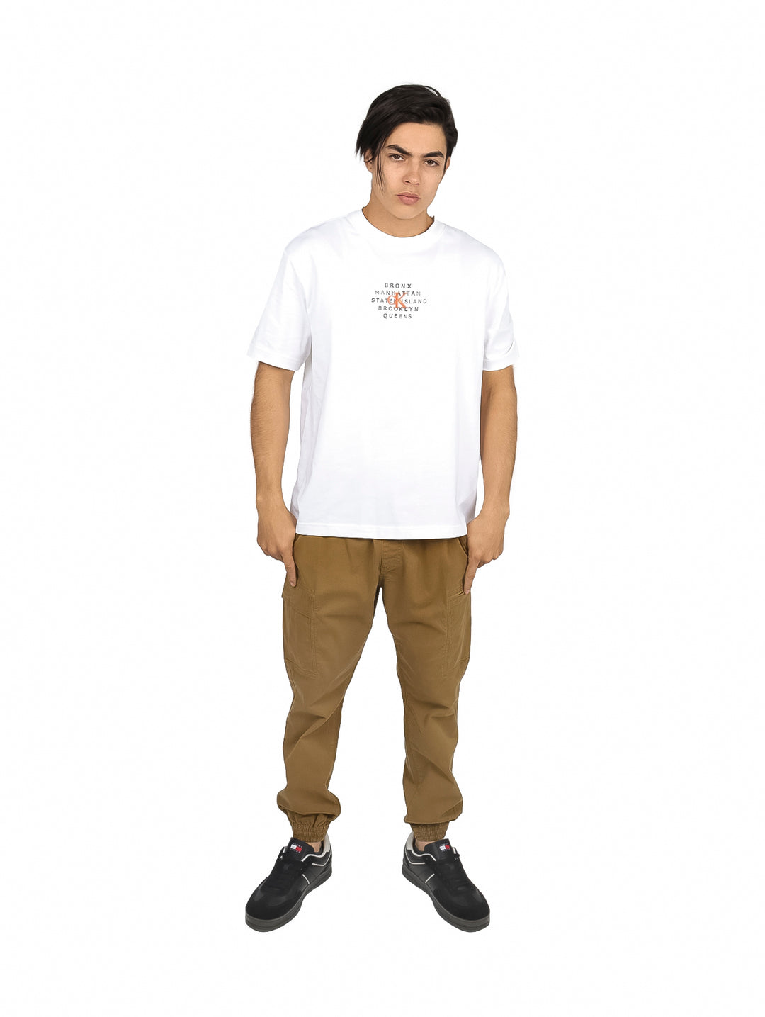 Hombre vistiendo playera blanca de manga corta Calvin Klein con texto en el pecho y pantalones caqui.