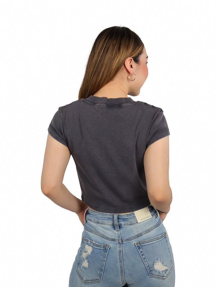 Mujer vistiendo una camiseta corta gris acanalada de Calvin Klein con logo en el pecho.