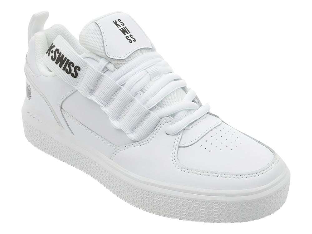 Tenis K-Swiss color blanco con agujetas y correa de velcro superior, suela blanca texturizada.